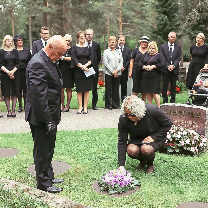 Hautajaisvieraita hautausmaalla.